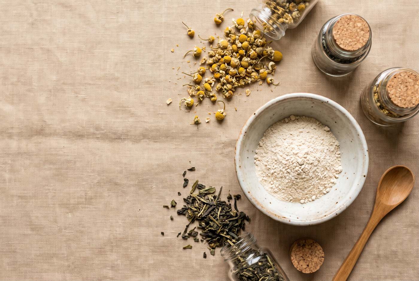Chamomile and green tea laid out on linen