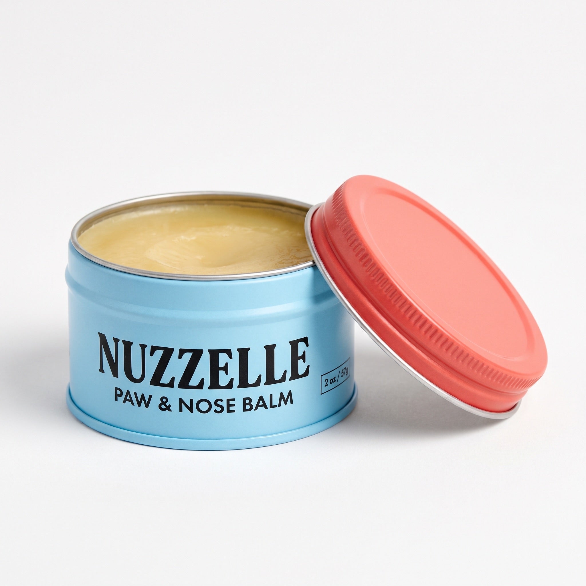 Nuzzelle Paw and Nose Balm tin packaging - sky blue metal tin with coral lid open showing balm